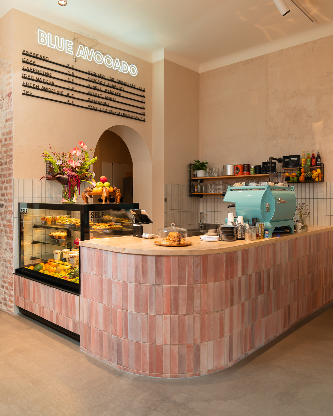 Innenraum des Blue Avocado Cafés mit Theke und Kaffeemaschine
