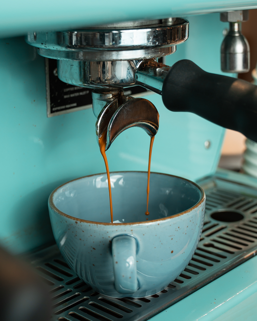 Kaffee wird in eine blaue Tasse gegossen